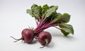 Two red beets with green leaves sit on a white surface Royalty Free Stock Photo