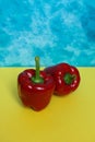 Two red bell peppers on colorful background. Royalty Free Stock Photo