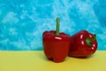 Two red bell peppers on colorful background. Royalty Free Stock Photo