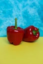 Two red bell peppers on colorful background. Royalty Free Stock Photo