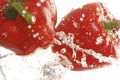 Two red bell peppers splashing in water Royalty Free Stock Photo