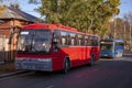 Two red and blue passenger buses standing along the road parked Royalty Free Stock Photo