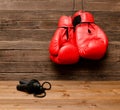 Two red boxing gloves hung on a wooden brown background, jump rope