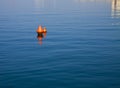 Two red buoys floating on blue waters Royalty Free Stock Photo