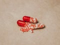 Two red capsule tablets with crumbling contents Royalty Free Stock Photo