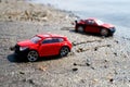 Two red cars on the beach, from the rest on the sand left traces on a summer day outside Royalty Free Stock Photo