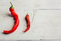 Two red chili peppers, on wooden background Royalty Free Stock Photo