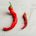 Two red chili peppers, on wooden background Royalty Free Stock Photo
