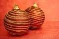 Two Red Christmas Toy With Gold Stripes On A Red Background