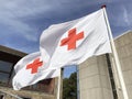 Two Red Cross flags waving in the wind against a blue sky. Royalty Free Stock Photo