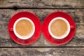 Two Red Cups of Coffee with Milk on old Wood Background. Royalty Free Stock Photo