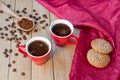 Two red cups of coffee with oatmeal cookies on a wooden table Royalty Free Stock Photo