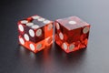 Two red dice on a black background with light. Royalty Free Stock Photo