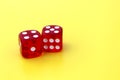 Two red dice lie on a yellow background with space for text. Royalty Free Stock Photo