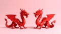 Two red dragons facing each other on a pink background, studio shot. Royalty Free Stock Photo