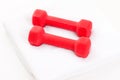 Two red dumbbells and white towel Royalty Free Stock Photo