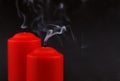 Two red extinguished candles with white smoke on black Royalty Free Stock Photo