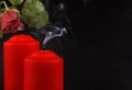 Two red extinguished candles with white smoke and withered rose flower on black Royalty Free Stock Photo