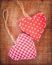 Two red fabric hearts on rustic canvas background Royalty Free Stock Photo