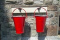 Two red fire buckets against a stone wall background Royalty Free Stock Photo