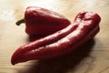 Two red, freshly cut peppers on a wooden table Royalty Free Stock Photo