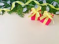 Two red gift boxes with yellow ribbon bow on beige background. Royalty Free Stock Photo