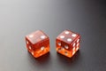 Two red glass dice on a black matte background with side lighting. Two and four with copy space Royalty Free Stock Photo