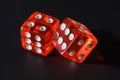 Two red glass dice on a dark leather background. The result is four and six or five. Two red dice on a dark textured background Royalty Free Stock Photo