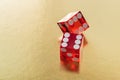 Two red glass dice on a gold background with space to copy. A dice on the edge and a six. Royalty Free Stock Photo