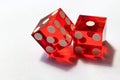 Two red glass dice on a gray background in sunlight. Result 1 and one on the edge, close-up with selective focus Royalty Free Stock Photo