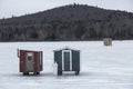 Two red and gray ice fishing shelters, Errol, New Hampshire. Royalty Free Stock Photo