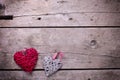 Two red and grey rustic decorative hearts on vintage wooden b