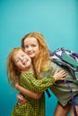 Two red haired child sister cute hugging isolated on blue background.