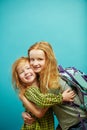 Two red haired child sister cute hugging isolated on blue background.