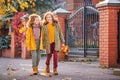 Two red-haired girls are walking down the street on a sunny autumn day Royalty Free Stock Photo