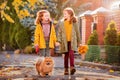 Two red-haired girls are walking down the street on a sunny autumn day. Walking with a small fluffy Pomeranian dog Royalty Free Stock Photo