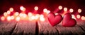 Two Red Hand Carved Wooden Hearts On Rustic Table With Glowing Bokeh Background