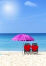 Two red heart on beach chair under pink umbrella with space on blue sea and clear sky background, summer outdoor day light Royalty Free Stock Photo