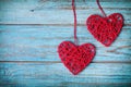 Two red heart hanging on turquoise vintage wall for Valentines day card