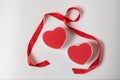 Two red heart-shaped boxes and satin ribbon on a white background. Symbol of love, Valentine`s Day Royalty Free Stock Photo