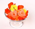 Two red hearts candies in glass bowl and rose petals Royalty Free Stock Photo