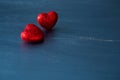 Two red hearts on dark blue or silver on wooden or metal background. Valentine's Day Royalty Free Stock Photo