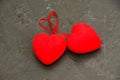 Two red hearts on a dark gray concrete background. Concept of romantic relationship and Valentine's Day celebration. Royalty Free Stock Photo