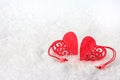 Two red hearts lie on the white fluffy snow in winter. Symbol of love. Valentine`s day Royalty Free Stock Photo