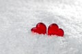 Two red hearts lie on the white fluffy snow in winter. Symbol of love. Valentine`s day Royalty Free Stock Photo