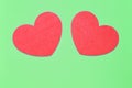 Two red hearts on a light green background closeup. Greeting card with copy space. Valentine`s Day concept Royalty Free Stock Photo