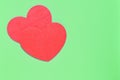 Two red hearts on a light green background closeup. Greeting card with copy space. Valentine`s Day concept Royalty Free Stock Photo