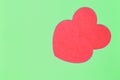 Two red hearts on a light green background closeup. Greeting card with copy space. Valentine`s Day concept Royalty Free Stock Photo