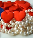 Two red hearts and pearls beads valentine& x27;s on a white background Royalty Free Stock Photo