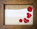 Two red hearts and rose candle flower in wooden frame with space on canvas fabric background Royalty Free Stock Photo